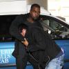 Kanye West tente de déborer la caméra d'un paparazzi à l'aéroport de Los Angeles, le 19 juillet 2013.