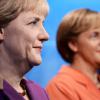 La nouvelle statue d'Angela Merkel (à gauche) a trouvé sa place à côté d'une ancienne datant de 2005 au musée Madame Tussauds à Berlin, le 19 septembre 2013.
