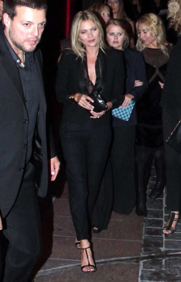 Kate Moss, sous bonne escorte lors de l'inauguration de la boutique Stuart Weitzman à Milan, le 19 septembre 2013.