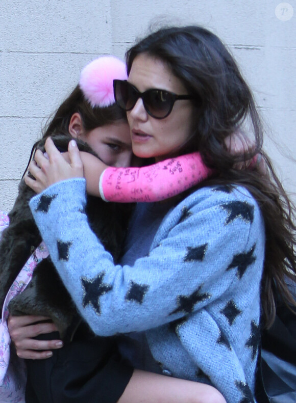 La jolie Katie Holmes accompagne sa fille Suri, qui a un plâtre rose au bras droit, à l'école à New York. Le 1er octobre 2013.