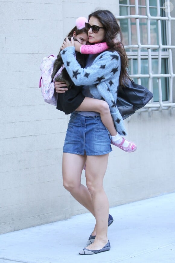 L'actrice Katie Holmes accompagne sa fille Suri, qui a un plâtre rose au bras droit, à l'école à New York. Le 1er octobre 2013.