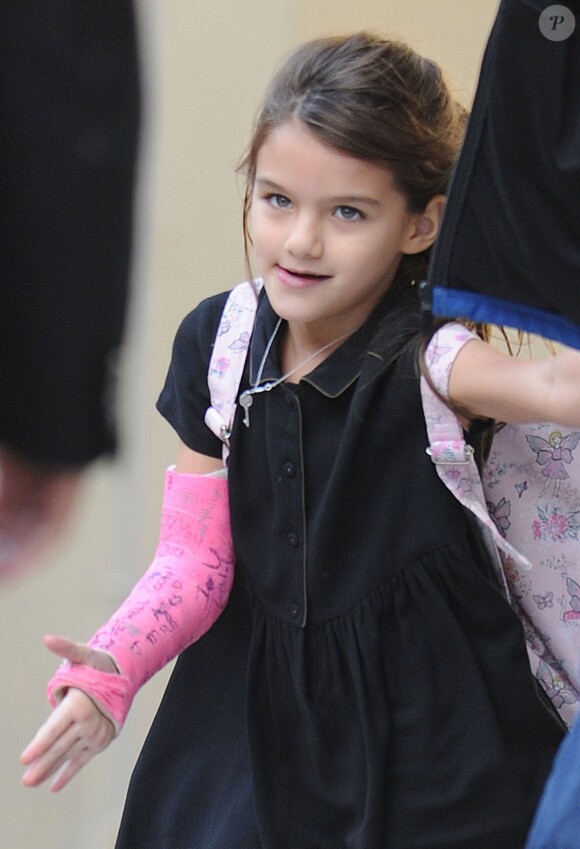 Suri Cruise, un plâtre rose au bras, à la sortie de son école à New York, le 30 septembre 2013.
