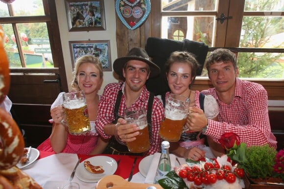 Philipp Lahm avec sa femme Claudia Lahm, Thomas Muller et son épouse Lisa Mueller à l'Oktoberfest à Munich le 6 octobre 2013.