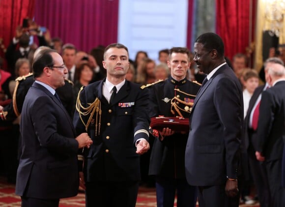 François Hollande et Pape Diouf lors de la remise des insignes de la Légion d'honneur et de l'Ordre national du Mérite par François Hollande au Palais de l'Elysée le 9 octobre 2013