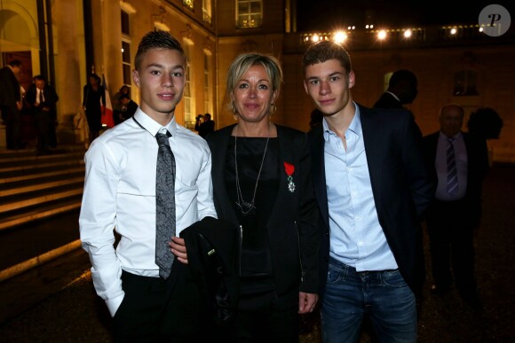 Cécile Nowak-Grasso entouré de ses fils lors de la remise des insignes de la Légion d'honneur et de l'Ordre national du Mérite par François Hollande au Palais de l'Elysée le 9 octobre 2013