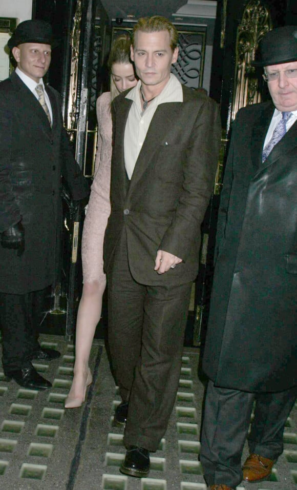 L'acteur américain Johnny Depp, teint en blond, et sa compagne Amber Heard sortant du restaurant Ronnie Scott à Londres, le 25 octobre 2013