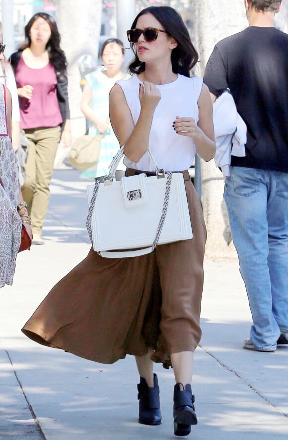 Rachel Bilson surprise sous le soleil de Beverly Hills, porte des bottines Alexander Wang (modèle Erin) et un sac Chanel (modèle Boy), compléments de son débardeur blanc et sa maxi-jupe. Le 19 octobre 2013.