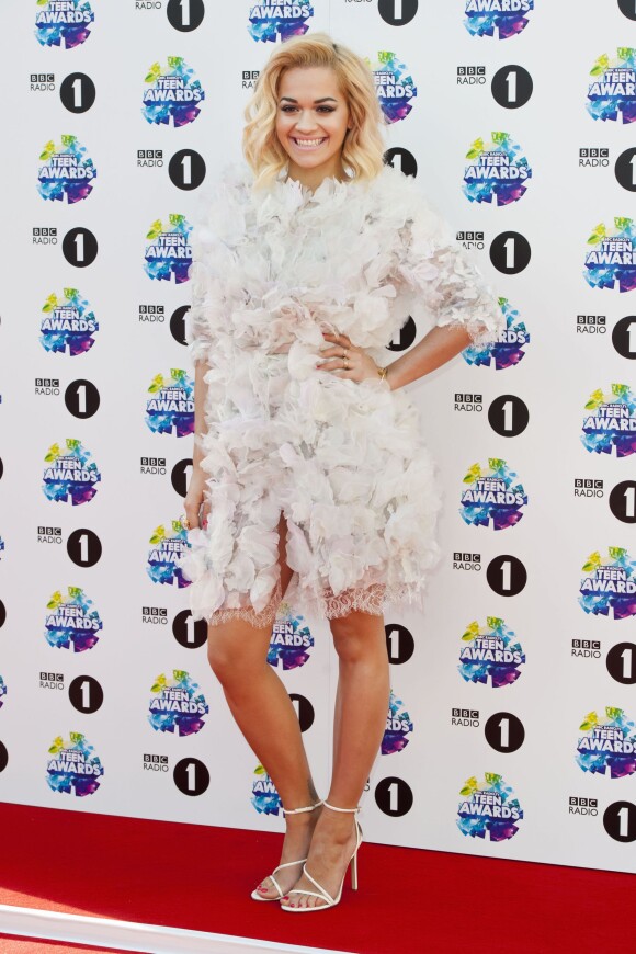 Rita Ora, vêtue d'une robe Marchesa (collection printemps-été 2014) et de sandales Brian Atwood, assiste aux BBC Radio 1's Teen Awards 2013 à la Wembley Arena. Londres, le 3 Novembre 2013.