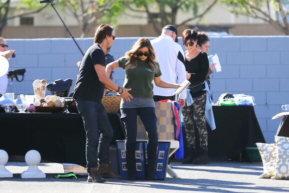 La petite chute de Kim Kardashian, rattrapée par son meilleur ami Jonathan Cheban lors du vide-grenier organisé par sa famille dans le quartier de Woodland Hills. Los Angeles, le 10 novembre 2013.