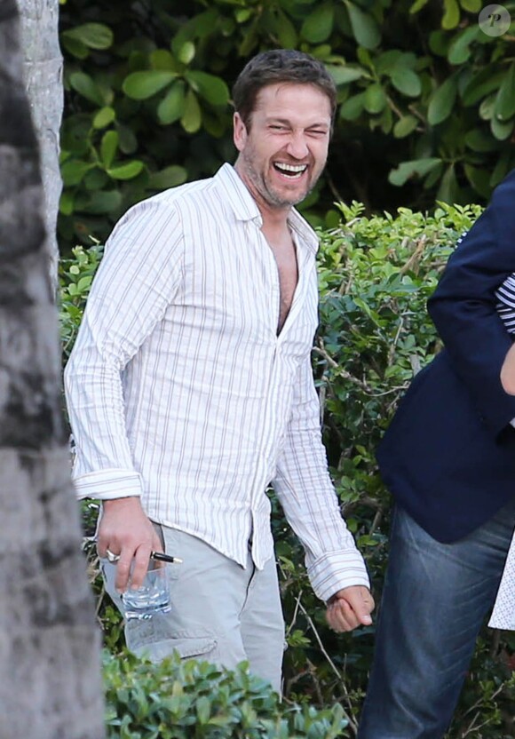 Gerard Butler, détendu avec des amis, se montre très proche et complice d'une mystérieuse inconnue au bord de la piscine de son hôtel à Miami, le 3 décembre 2013.