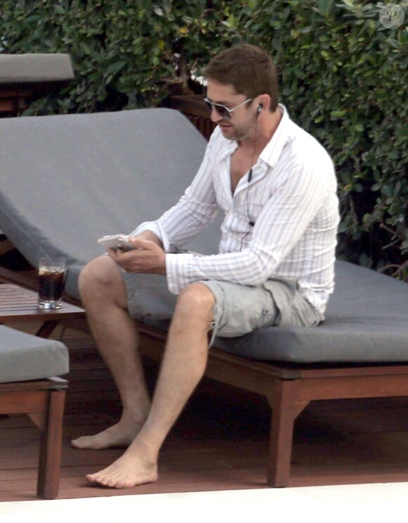 Gerard Butler, détendu avec des amis, se montre très proche et complice d'une mystérieuse inconnue au bord de la piscine de son hôtel à Miami, le 3 décembre 2013.