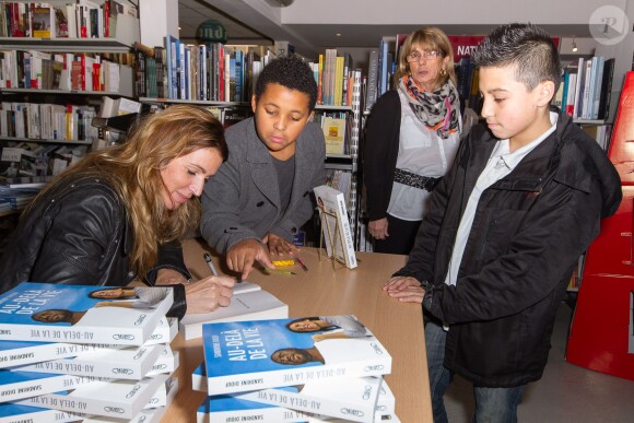 Sandrine Diouf, en présence de son jeune fils Isaac, dédicace son livre "Au-delà de la vie", paru aux éditions Michel Lafon, à la librairie du Prado à Marseille. Le 18 janvier 2014.