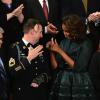 La First Lady Michelle Obama au côté du soldat Cory Remsburg, lors du discours annuel de Barack Obama sur l'état de l'Union, devant les membres du Congrès, ainsi que le vice-président Joe Biden, à Washington, le 28 janvier 2014.