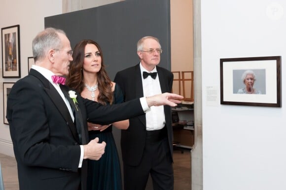 Kate Middleton avec David Nairne devant un portrait d'Elizabeth II à la National Portrait Gallery, à Londres le 11 février 2014, à l'occasion de la soirée Portrait Gala 2014.