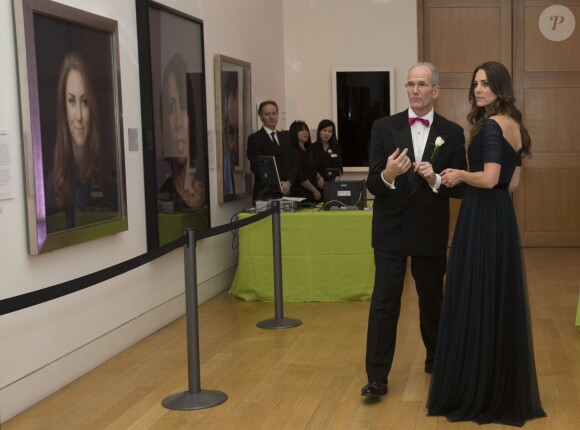 Kate Middleton devant son portrait signé Paul Emsley avec le maître des lieux David Nairne à la National Portrait Gallery, à Londres le 11 février 2014, à l'occasion de la soirée Portrait Gala 2014.