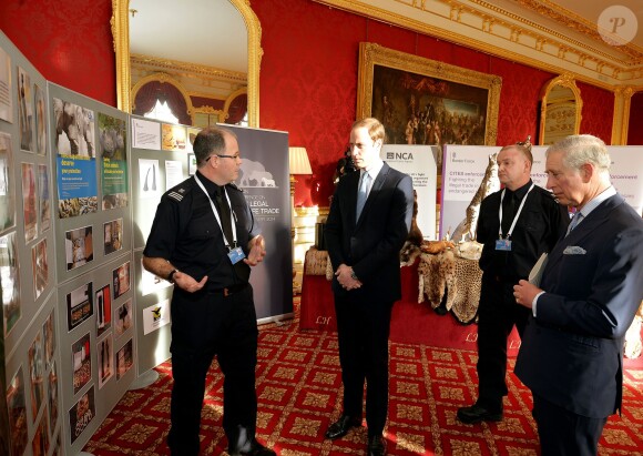 Le prince Charles et ses fils, le prince William et le prince Harry visitent une exposition sur le braconnage, avant d'assister à la conférence sur le commerce illicite de la faune à Lancaster House, à Londres, le 13 février 2014.