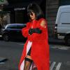 Rihanna, en manteau de fourrure rouge, robe noire et portes-jarretelles à Paris, le 28 février 2014.