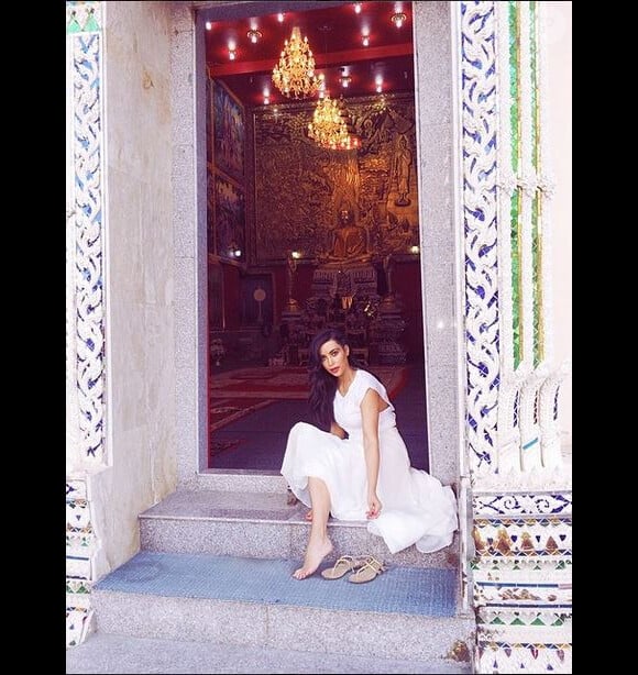 Kim Kardashian se la joue spirituelle en posant pieds nus à l'entrée d'un temple lors de vacances en Thaïlande. Mars-avril 2014.