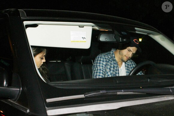 Ashton Kutcher et sa fiancée Mila Kunis, enceinte de leur premier enfant, rejoignent la voiture à la sortie de chez Umami Burger à Toluca Lake, Los Angeles, le samedi 12 avril 2014.