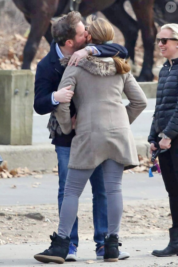 Chris O'Neill embrassant la princesse Madeleine de Suède, son épouse, dans Central Park le 22 mars 2014 à New York lors d'une promenade avec leur fille Leonore et des amis.