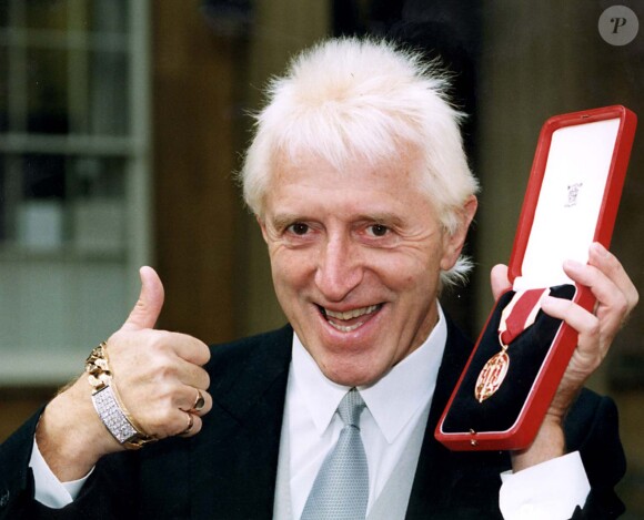 Jimmy Savile décoré par la reine d'Angleterre le 24 octobre 1996. 