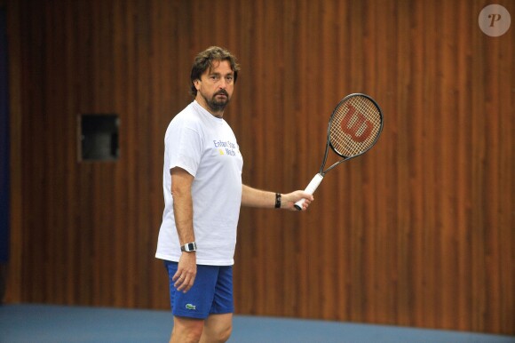 Henri Leconte, parrain de l'association 'Enfant Star et Match', participe à un tournoi de tennis organisé à Levallois-Perret le 10 février 2014