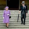 La reine Elizabeth II et le prince Philip, duc d'Edimbourg descendent les marches de Buckingham Palace pour rejoindre les invités de la première garden party royale de l'année, le 21 mai 2014
