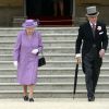 La reine Elizabeth II et le prince Philip, duc d'Edimbourg descendent les marches de Buckingham Palace pour rejoindre les invités de la première garden party royale de l'année, le 21 mai 2014