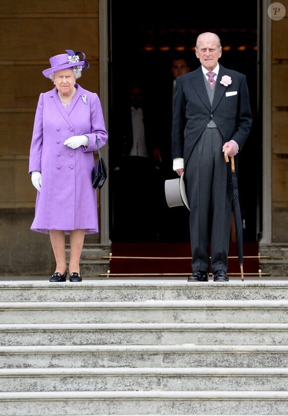 La reine Elizabeth II et le prince Philip, duc d'Edimbourg descendent les marches de Buckingham Palace pour rejoindre les invités de la première garden party royale de l'année, le 21 mai 2014