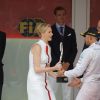 La princesse Charlene de Monaco félicitant Lewis Hamilton pour sa 2e place le 25 mai 2014 lors du Grand Prix de F1 de Monaco, sous le regard de son mari le prince Albert ainsi que ses neveux Andrea et Pierre Casiraghi.