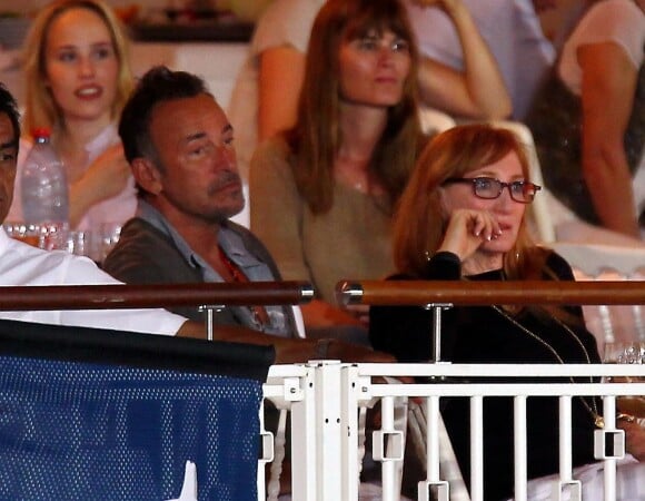 <p>Bruce Springsteen et sa femme Patti Scialfa (derrière eux, Marina Hands) dans les tribunes du Stade des Hespérides le 12 juin 2014, au premier soir du Jumping international de Cannes, encourageant leur fille Jessica Springsteen. Hélas, la jeune cavalière de 21 ans n'a pas joué les premiers rôles.</p>