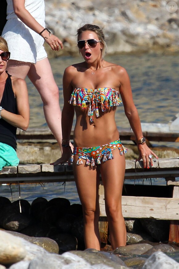 Alex Gerrard tente de se baigner sous le soleil d'Ibiza en compagnie d'une amie, le 15 juin 2014