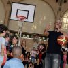 Tony Parker lors d'un événement organisé par la Halle au Carreau du Temple à Paris, le 2 juillet 2014, au milieu de dizaines d'enfants