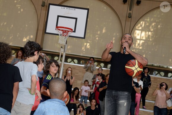 Tony Parker lors d'un événement organisé par la Halle au Carreau du Temple à Paris, le 2 juillet 2014, au milieu de dizaines d'enfants