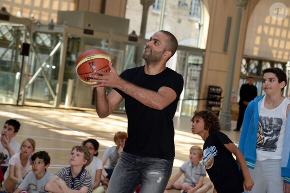 Tony Parker lors d'un événement organisé par la Halle au Carreau du Temple à Paris, le 2 juillet 2014, au milieu de dizaines d'enfants