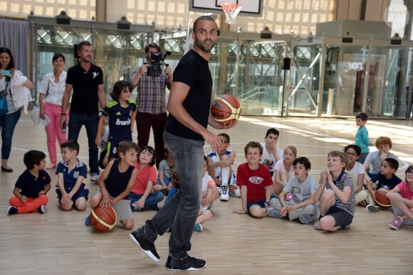 Tony Parker lors d'un événement organisé par la Halle au Carreau du Temple à Paris, le 2 juillet 2014, au milieu de dizaines d'enfants