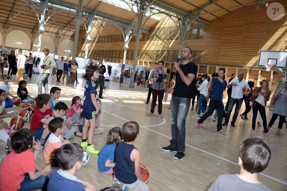 Tony Parker lors d'un événement organisé par la Halle au Carreau du Temple à Paris, le 2 juillet 2014, au milieu de dizaines d'enfants