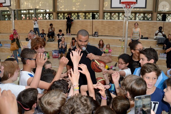 Tony Parker lors d'un événement organisé par la Halle au Carreau du Temple à Paris, le 2 juillet 2014, au milieu de dizaines d'enfants