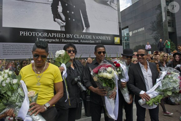 Les frères Jackson rendent hommage à Michael Jackson devant une photo de 1977 du chanteur du photographe Claude Vanheye installée au Gustav Mahlersquare à Amsterdam, le 30 juillet 2014. 