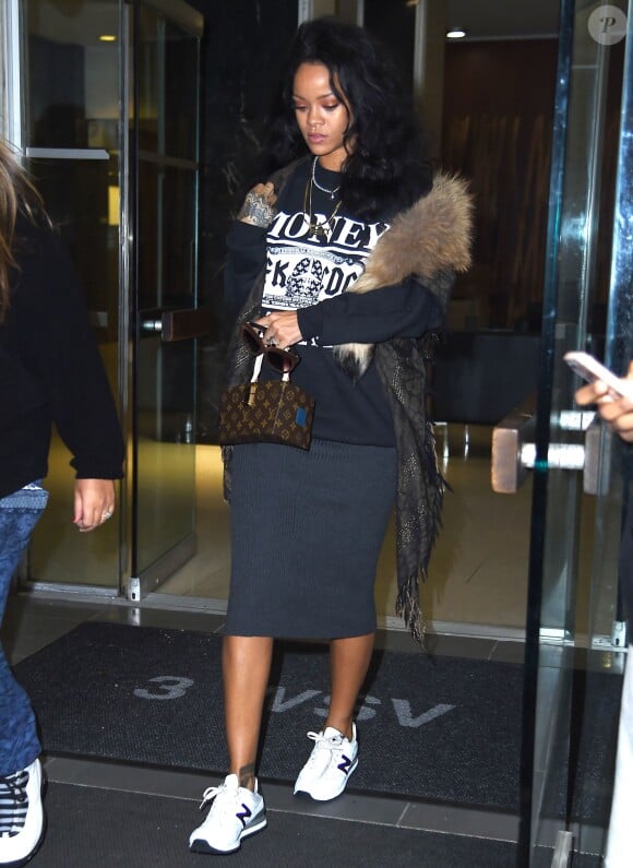 Rihanna quitte un cabinet dentaire à New York, habillée d'un pull Spye + Shicnyc, une écharpe Roberto Cavalli, une jupe grise, un sac Louis Vuitton (modèle Twisted Box par Frank Gehry) et des baskets New Balance. Le 21 octobre 2014.