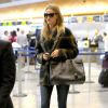 Rosie Huntington-Whiteley à l'aéroport LAX de Los Angeles, porte un manteau à carreaux, un sac et des bottines Saint Laurent. Le 20 novembre 2014.