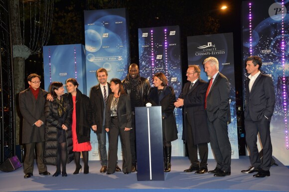 Omar Sy, en présence de la maire de Paris Anne Hidalgo, assure le lancement des illuminations sur l'avenue des Champs-Élysées à Paris le 20 novembre 2014.