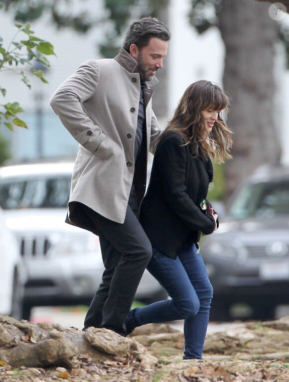 Ben Affleck et sa femme Jennifer Garner, complices dans les rues de Brentwood, le 11 décembre 2014. Ben fume une cigarette et se désaltère ensuite avec un Perrier.