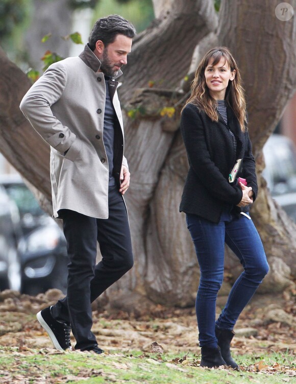 Ben Affleck et sa femme Jennifer Garner, complices dans les rues de Brentwood, le 11 décembre 2014. Ben fume une cigarette et se désaltère ensuite avec un Perrier.
