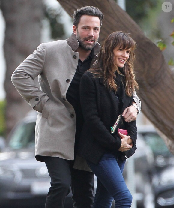 Ben Affleck et sa femme Jennifer Garner, complices dans les rues de Brentwood, le 11 décembre 2014. Ben fume une cigarette et se désaltère ensuite avec un Perrier.