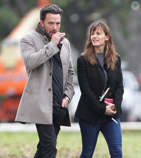 Ben Affleck et sa femme Jennifer Garner, complices dans les rues de Brentwood, le 11 décembre 2014. Ben fume une cigarette et se désaltère ensuite avec un Perrier.