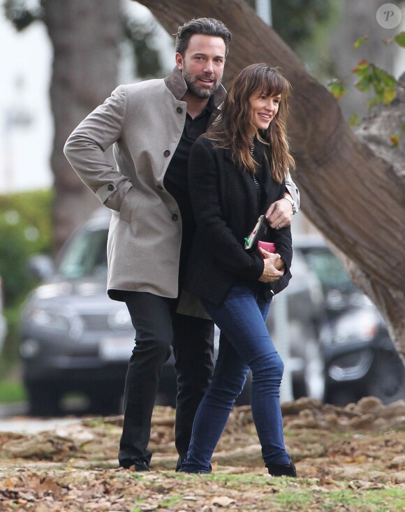 Ben Affleck et sa femme Jennifer Garner, complices dans les rues de Brentwood, le 11 décembre 2014. Ben fume une cigarette et se désaltère ensuite avec un Perrier.