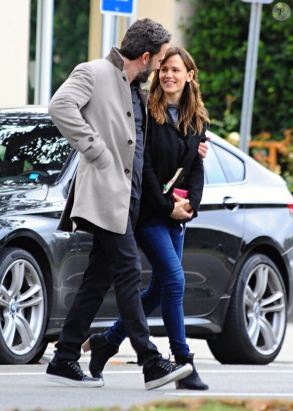 Ben Affleck et sa femme Jennifer Garner, complices dans les rues de Brentwood, le 11 décembre 2014. Ben fume une cigarette et se désaltère ensuite avec un Perrier.