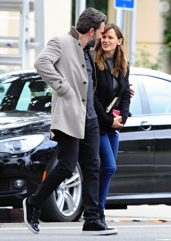 Ben Affleck et sa femme Jennifer Garner, complices dans les rues de Brentwood, le 11 décembre 2014. Ben fume une cigarette et se désaltère ensuite avec un Perrier.