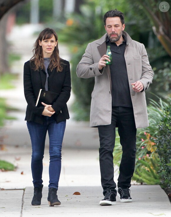 Ben Affleck et sa femme Jennifer Garner, complices dans les rues de Brentwood, le 11 décembre 2014. Ben fume une cigarette et se désaltère ensuite avec un Perrier.